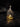 Small glass bottle with a stopper containing a small figurine on a dark surface
