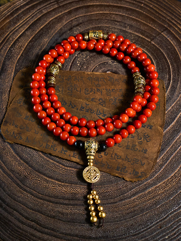 Red beaded bracelet with gold accents on a textured brown background