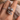Close-up of a hand wearing two crystal rings with a soft, blurred background.