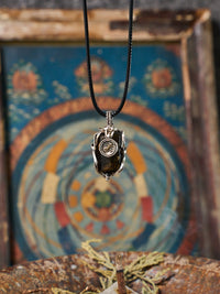 Necklace with a pendant in front of a colorful circular design