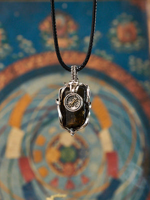 Necklace with a pendant in front of a colorful circular design