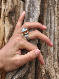Hand with a silver ring holding onto a wooden surface